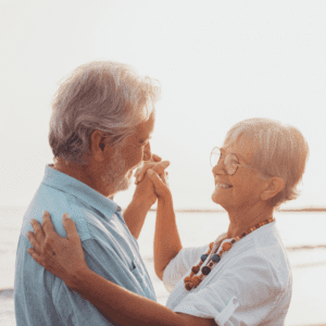 an older couple dancing on the beach